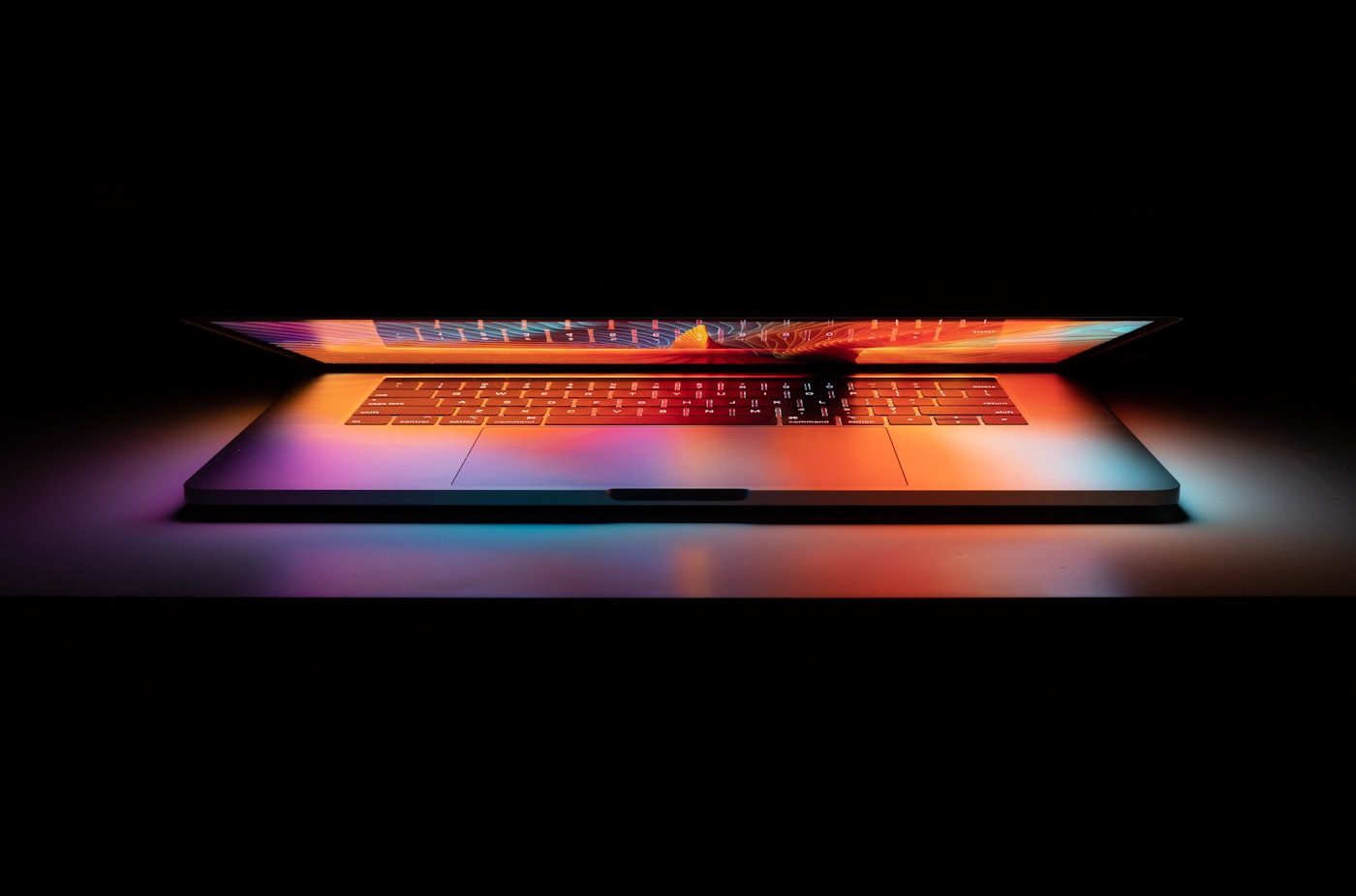 MacBook Neo open on a dark backdrop with a colorful screen